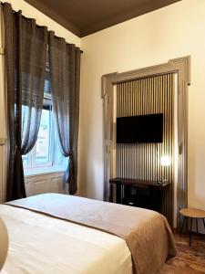ein Schlafzimmer mit einem Bett und einem Flachbildfernseher in der Unterkunft Bed and Chic art rooms in Triest + 33 Fotos
