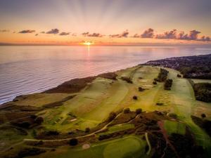an aerial view of a golf course next to the water at The Light Keepers Retreat in Cromer