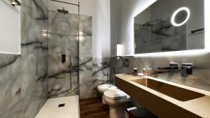 a bathroom with a toilet and a sink and a shower at Bed and Chic art rooms in Trieste