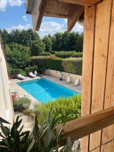 vista sulla piscina da una casa di Gîte dans moulin - Chic et Charme - Piscine et Spa a Rouessé-Vassé