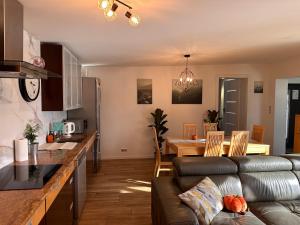 BorkowoにあるJacuzzi Bubble Apartment - 15 minutes drive from the Old Townのソファとテーブルのあるキッチンとリビングルーム
