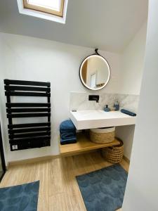 un bagno con un lavandino bianco e uno specchio di Gîte dans moulin - Chic et Charme - Piscine et Spa a Rouessé-Vassé
