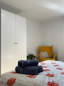 BorkowoにあるJacuzzi Bubble Apartment - 15 minutes drive from the Old Townの青いタオルが敷かれたベッドと黄色い椅子