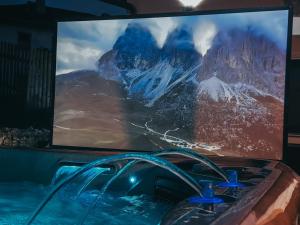 a large television with a view of a mountain at Waldklang-Suite in Bad Koetzting