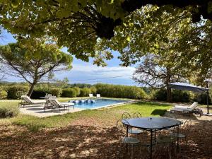 a backyard with a table and a swimming pool at Domaine du Cèdre Eternel in Saint-Colomb-de-Lauzun