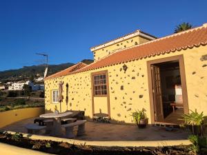 a building with a patio with a table and benches at Los Frailes in Breña Baja +16 photos