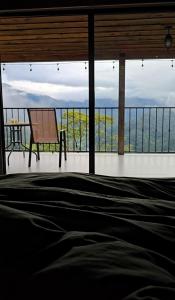 Un dormitorio con una cama y vista al mar. en Bosque Tapantí, cerca del PN Tapantí en Orosí, Cartago, Costa Rica, en Purisil 34 fotos más