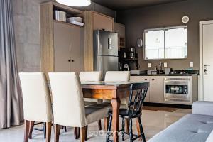 a kitchen and dining room with a table and chairs at Duplex pé na areia com vista deslumbrante RAT001 in Porto Belo