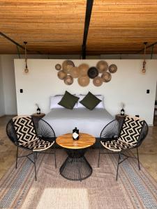 a bedroom with a bed with two chairs and a table at Wayma House in Villeta