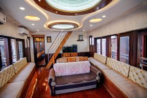 Una sala de tren con sofás y mesas y un techo. en Vistara Backwater Cruise, en Alleppey