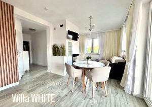 a living room with a white table and chairs at Dom Michałki Luksusowa willa z ogrodem in Michalki +10 photos