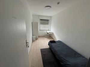 a room with a bed and a desk and a window at Moderne Zimmer nähe A3 in Ransbach-Baumbach