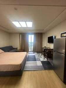 a hotel room with a bed and a refrigerator at Spacious Studio CondoinClark!FreeParking! in Fort Stotsenburg