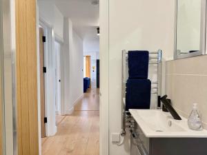 een badkamer met een wastafel en een spiegel en een hal bij Spacious Preston Circus Flat - Great for Family, Group, Couples - Close to Station in Brighton & Hove +16 foto's