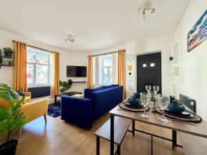 een woonkamer met een tafel en een blauwe bank bij Spacious Preston Circus Flat - Great for Family, Group, Couples - Close to Station in Brighton & Hove