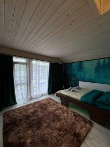 a bedroom with a bed and a large window at Fox home in Khashchovanoye