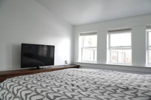 a bedroom with a large bed and a flat screen tv at Unique private room and bath in Halifax