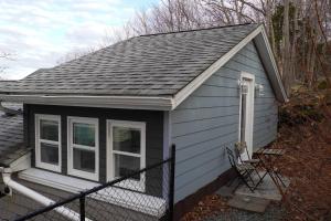 a small house with a gray roof and a window at Unique private room and bath in Halifax