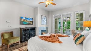 ラキンタにあるLV033 Quaint Downstairs Legacy Villas Suiteのベッドとテレビと椅子のある寝室