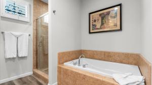 ラキンタにあるLV033 Quaint Downstairs Legacy Villas Suiteの浴槽とシャワー付きのバスルーム