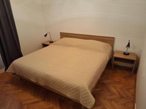 a bedroom with a bed and a lamp on a wooden floor at Apartment Roland in Vrsar