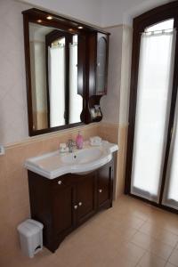 y baño con lavabo y espejo. en Postiglione Country House, en Cingoli