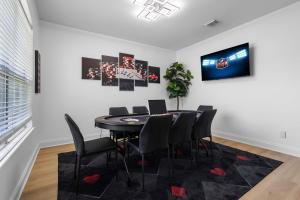a dining room with a black table and chairs at Heated Pool & Spa Mini Golf Bowling Game Room perfect for family in Rockwall