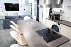 - une cuisine avec une table et des chaises blanches dans l'établissement Villa Celesto - Piscine et Jacuzzi privé, à Marseille