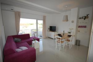 a living room with a purple couch and a table at Apartments Curicta 1 in Krk