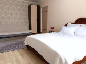 a bedroom with a large white bed and a mattress at Nectar Apartments in Aktobe