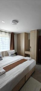 a large white bed in a bedroom with a window at Perfect palm Condos-Kings Sapphire in Nakuru