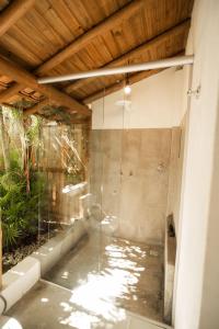una doccia con una porta in vetro in un bagno di Pousada Lua Cheia Caraíva a Caraíva