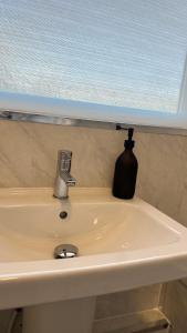 a bathroom sink with a soap dispenser on it at Jarrow Contractor & professional accommodation, Near port & hospital, 3bedroom apartment near Newcastle, free parking in Jarrow