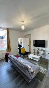a living room with a large bed and a tv at Jarrow Contractor & professional accommodation, Near port & hospital, 3bedroom apartment near Newcastle, free parking in Jarrow