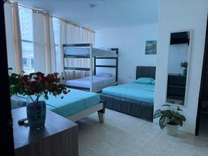 a room with two bunk beds and a table at Arenamar Hotel Rodadero in Rodadero