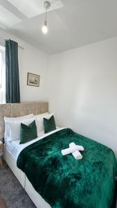 - un lit avec une couverture verte dans l'établissement Jarrow Haven Contractor Family Stay with FREE Parking Sleeps 8, à Jarrow