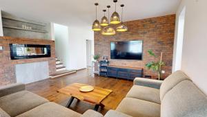 a living room with two couches and a brick wall at Exkluzívny rodinný dom Trnava - rodiny, pracovné cesty in Trnava