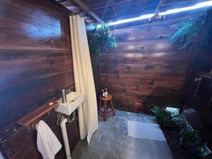 a bathroom with a sink and a wooden wall at Glamping Rincón de Lavanda in Texcoco de Mora +22 photos