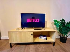 コベントリーにあるStylish - Coventry City Centre Stayの木製のエンターテイメントセンターの上に座ったテレビ