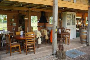 a kitchen and dining room with tables and chairs at Kampeerbeleving Dijksehoeve in Nistelrode