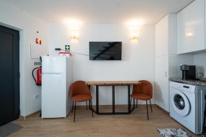 a kitchen with a table and a refrigerator at O Abrigo do Fetal in Reguengo do Fetal