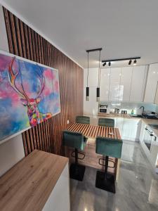 a kitchen with a table and a painting of a deer at Apartament Cysterska 18/24 in Wągrowiec