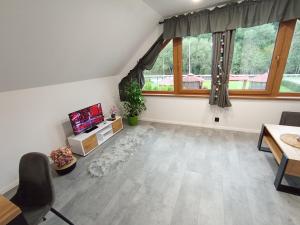 a living room with white walls and a large window at Domek Wrzos in Brenna
