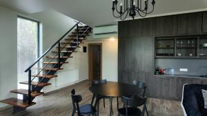 a dining room with a table and a spiral staircase at Kachreti Ambassadori Golf Resort, 16 Villa in Kachretʼi