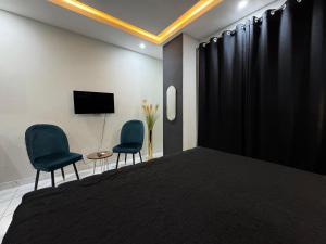 a bedroom with two chairs and a bed and a tv at Furnished Apartment Islamabad in Islamabad