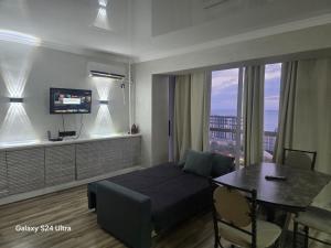 a bedroom with a bed and a table and a dining room at Квартира in Aktau