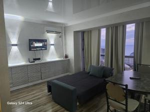 a bedroom with a bed and a table and a dining room at Квартира in Aktau