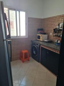 a kitchen with a washing machine and a microwave at Dar MARRAKECH in Tetouan
