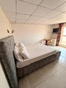 a bedroom with a bed in a room with a table at AS Appartement meublé in Bamako