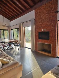 a living room with a brick wall with a fireplace at Casa em Chácara com Cacheira in Muzambinho